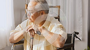 Pensive disabled elderly patient sit on wheelchair alone