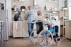 Pensive disabled elderly person in the kitchen