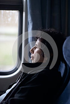 Pensive Elderly Lady Gazing Out Train Window