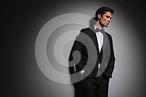 Pensive elegant man wearing tuxedo looks away to side