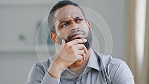 Pensive ethnic bearded African American man thinking businessman searching solution of difficult problem boss think