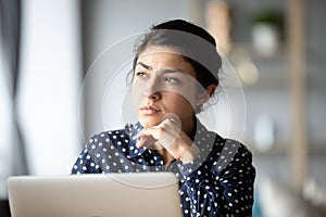 Pensive ethnic woman look in distance making decision