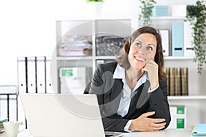 Pensive executive lady thinking looking up at office