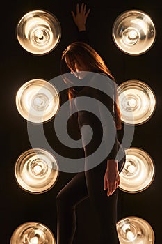 Pensive female dancer performing show dance in darkness.