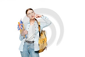 Pensive girl with backpack holding copybooks and uk flag