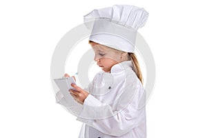 Pensive girl chef white uniform isolated on white background. Writing the notes, looking at the note. Landscape image