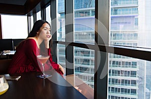 Pensive girl having a drink in a bar