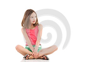 Pensive girl sitting with legs crossed