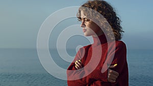 Pensive girl standing at seaside. Thoughtful woman face with closed eyes