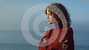 Pensive girl standing at seaside. Thoughtful woman face with closed eyes