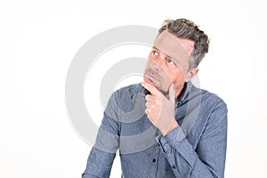 Pensive handsome man in casual blue shirt hand fingers on chin posing isolated on white background studio portrait