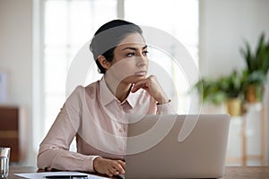 Pensive indian woman look in distance planning thinking