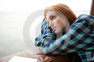 Pensive lady listening to music and looking away