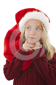 Pensive little girl in red Santa hat.