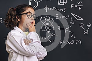 Pensive little girl scientist in lab coat