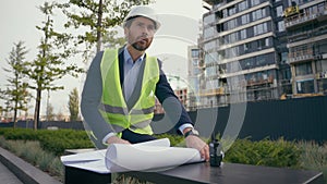 Pensive male architect thoughtful looking around think check urban infrastructure manufacture blueprint thinking worker