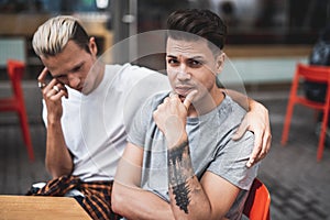 Pensive males thinking and resting together outdoor