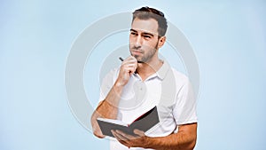 pensive man holding pen and notebook