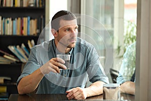 Pensive man looking throw window in a coffee shop