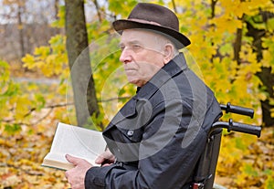 Pensive man reading outdoors in autumn