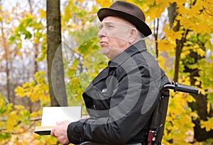 Pensive man reading on park in autumn