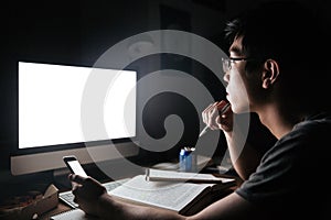 Pensive man studying with blank screen computer and smartphone