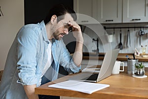 Pensive man work look at laptop screen thinking