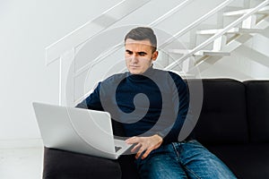 Pensive man working on laptop at home