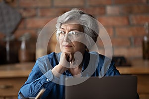 Pensive mature 60s woman look in distance thinking