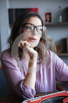 Pensive mature authoress in eyeglasses thinking and looking away