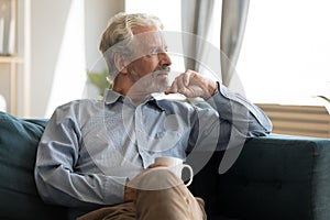 Pensive mature man look in distance thinking or daydreaming