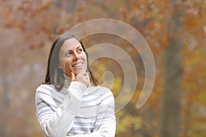 Pensive middle age woman in a forest in autumn