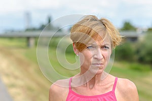 Pensive middle-aged woman pursing her lips