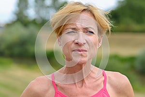 Pensive middle-aged woman pursing her lips