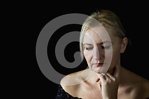 Pensive middle aged woman supporting her chin by hand