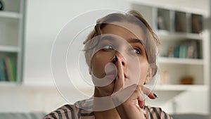 Pensive millennial girl looking webcam closeup. Thinking woman watching webinar