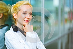 Pensive modern business woman near office building