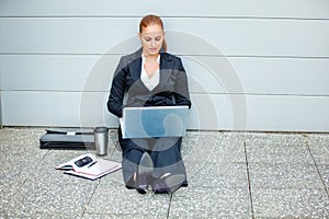 Pensive modern business woman using laptop