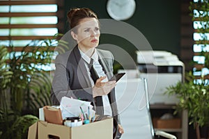 pensive modern woman worker in modern green office