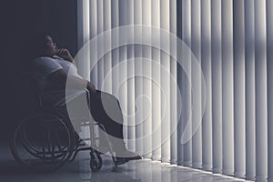 Pensive obese woman sitting in the wheelchair