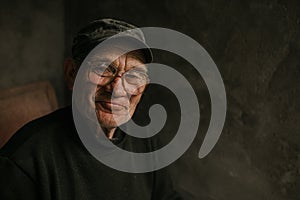 Pensive old man in glasses with gray hair