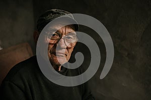 Pensive old man in glasses with gray hair