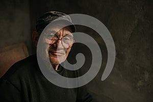 Pensive old man in glasses with gray hair