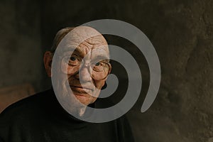 Pensive old man in glasses with gray hair