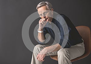 Pensive old man locating on seat
