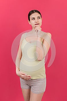 Pensive pregnant woman choosing name for baby on colored background. Dream and Happy Pregnant Woman Thinking Imagining