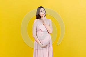 Pensive pregnant woman choosing name for baby on colored background. Dream and Happy Pregnant Woman Thinking Imagining Motherhood