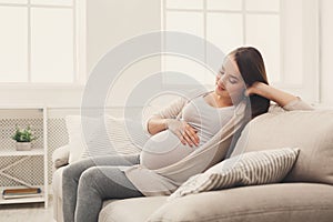 Pensive pregnant woman dreaming about child