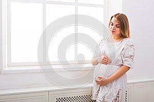 Pensive pregnant woman dreaming about child, copy space.