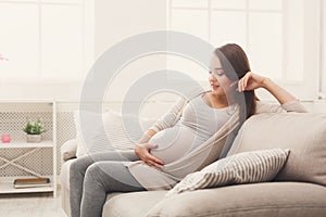 Pensive pregnant woman dreaming about child